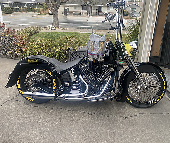 Custom black Harley-Davidson Softail with ape hangers and spoked wheels